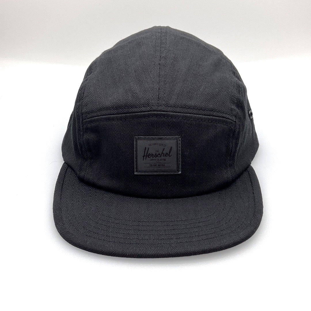 Black Herschel 5 Panel Hat with a black logo on the front panel, white background.