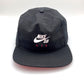 Nike Air SB Black 5 Panel Hat, Nike Air SB logo on front, with white background.
