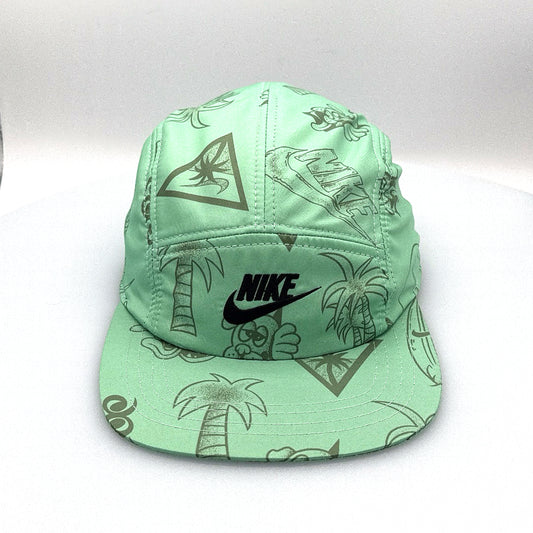 Green NIKE Swim Shorts upcycled into a 5 Panel Hat, black iconic NIKE logo in front, with a white background.