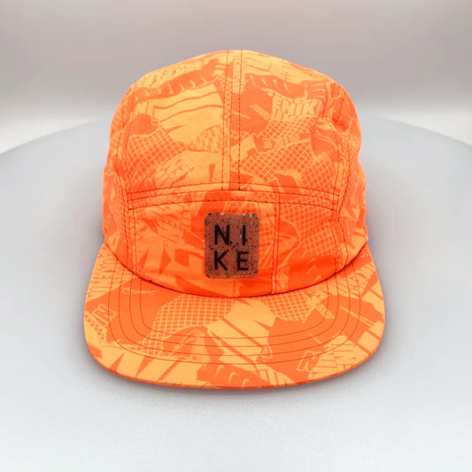 Oragne NIKE Swim Shorts upcycled into a 5 Panel Hat, rubber NIKE logo in front, with a white background.