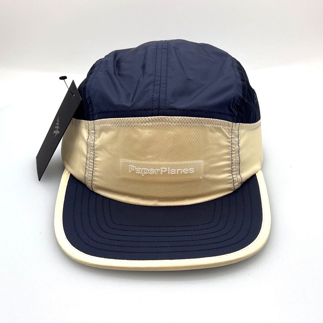 Nylon navy and off white Paper Planes 5 Panel Hat, clear logo on the front, with a white background.