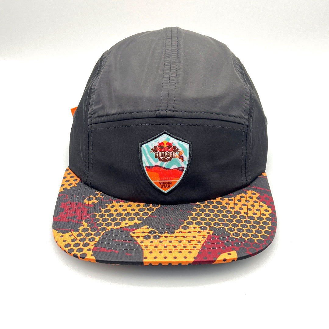 Red, orange and black RedBull Rampage 5 Panel  Hat, Virgin Utah logo on the front, with a white background.
