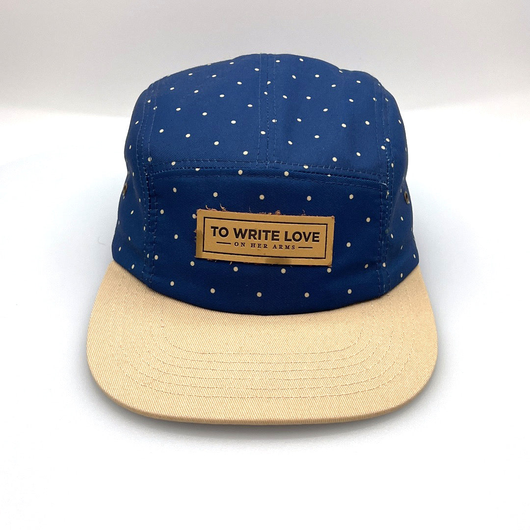 Tan and navy polka dots TWLOHA 5 Panel Hat, leather logo on the front, with a white background.