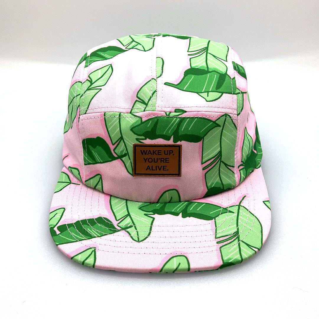 Pink and green floral TWLOHA 5 Panel Hat, with a white background.