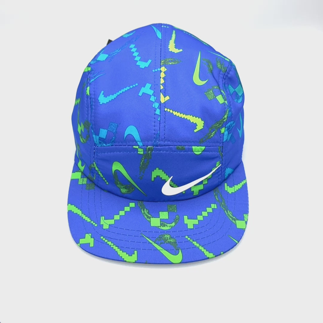 Spinning blue NIKE Swim Shorts upcycled into a 5 Panel Hat, iconic swoosh NIKE logo in front, with a white background.