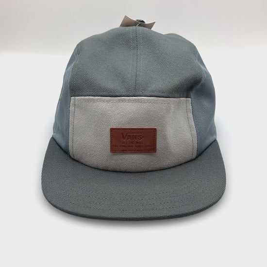 Spinning blue, light grey and dark grey Vans 5 Panel Hat, leather logo on the front, with a white background.