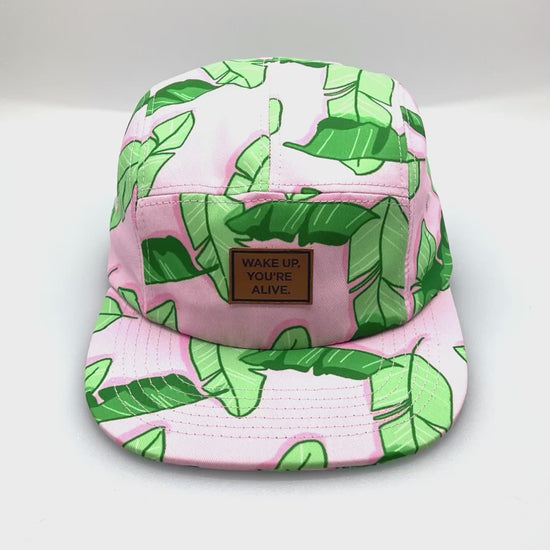 Spinning pink and green floral TWLOHA 5 Panel Hat, with a white background.