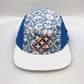 Spinning white and blue X Puma 5 Panel Hat, with a white background.