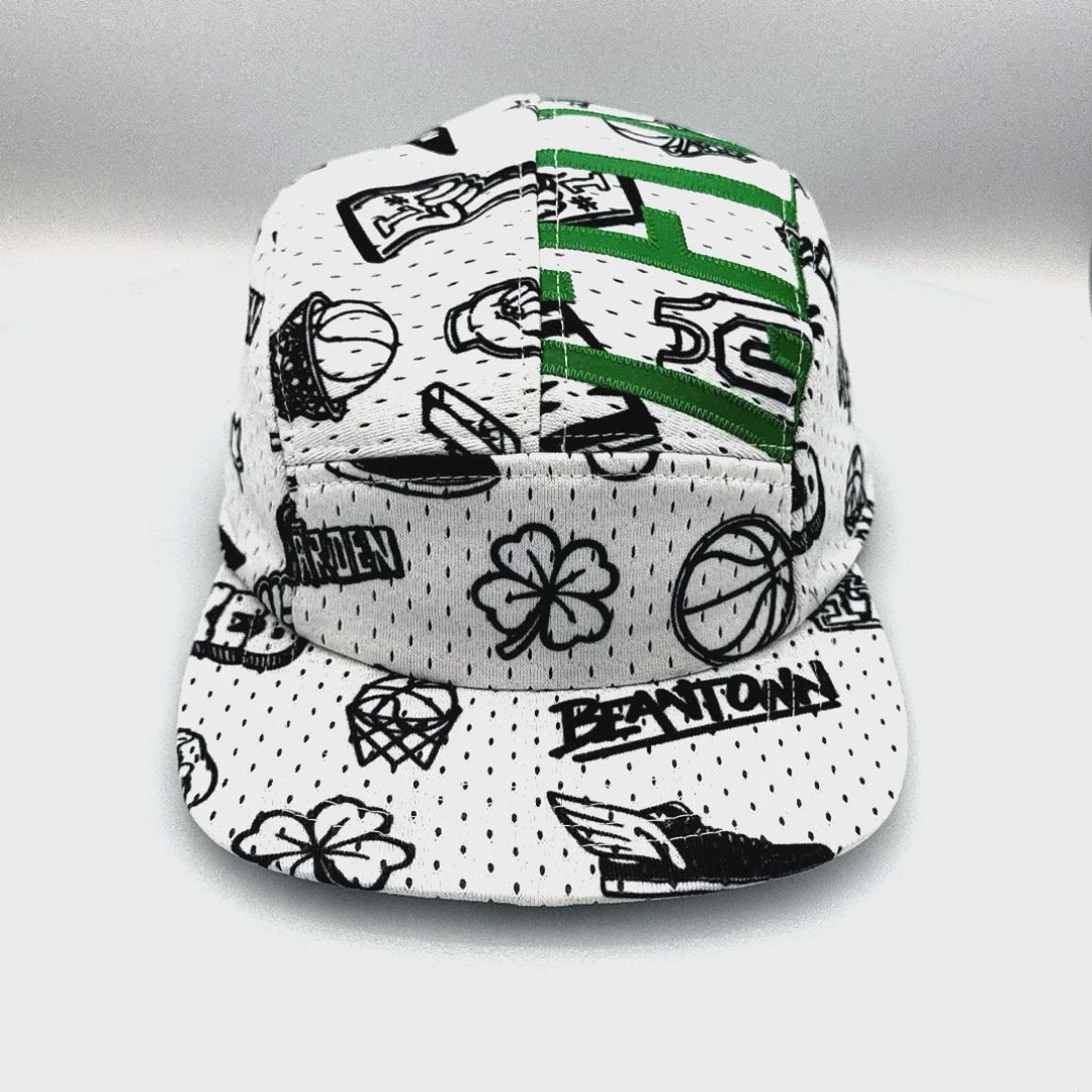 Spinning white and green Mitchell & Ness Larry Bird jersey upcycled to a 5-Panel Hat.