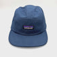Spinning navy Patagonia 5 Panel Hat, iconic logo on the front, with a white background.
