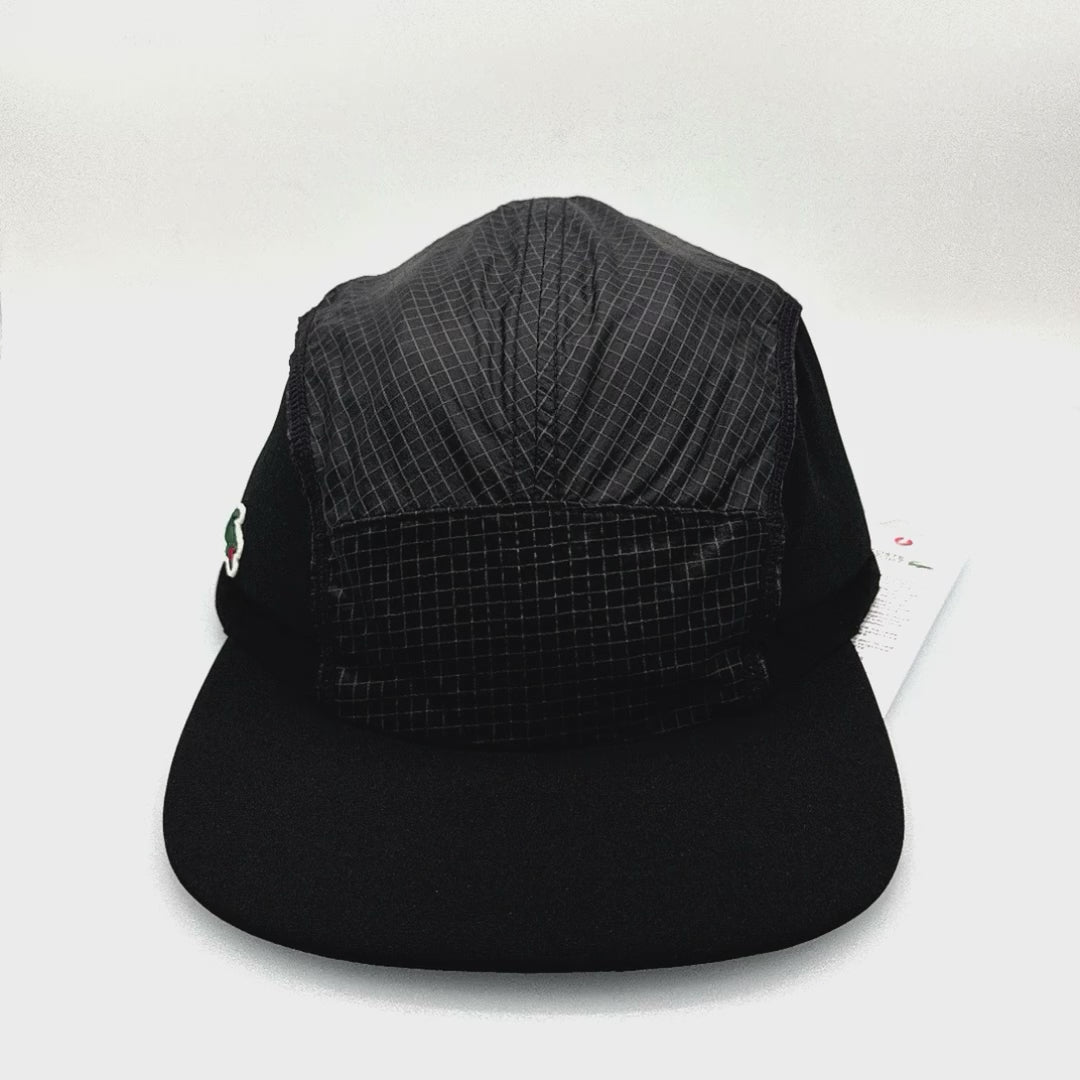 Spinning Black Nylon Lacoste 5 Panel, green alligator logo on the side panel, with white background.